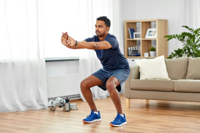 Man doing a squat exercise in his living room